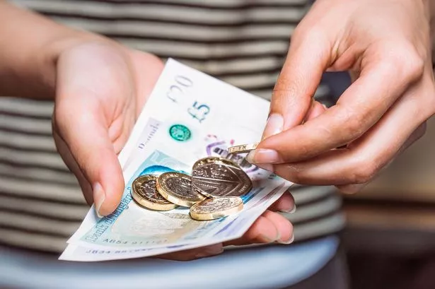 Detail of a woman counting money for payment.