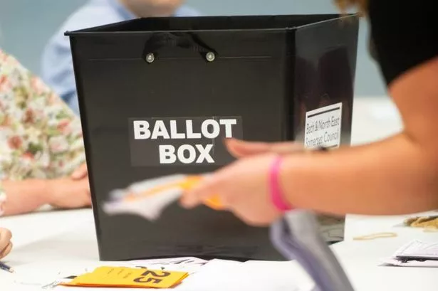 Black ballot box with a person counting votes