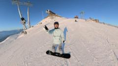 Online Chinese influencer Yao readies himself to snowboard down a snow-covered mountain peak in Xinjiang, China