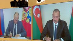 Владимир Путин (слева) и Ильхам Алиев подписывают соглашение о прекращении боевых действий в Нагорном Карабахе