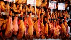 A butcher shop sells Spanish speciality ham in the food bazar Mercado de San Miguel in Madrid