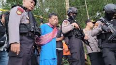 Police escort the suspect Slamet Tohari out of his home in the Banjarnegara region of Central Java.