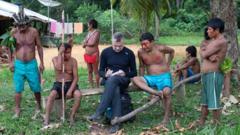 Dom Phillips taking notes as he talks to indigenous people at Aldeia Maloca Papiú, Roraima State, Brazil in 2019