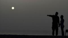 A couple look at the sea as a vast cloud of Sahara dust is blanketing the city of Havana on June 24, 2020.