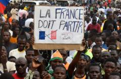 демонстранты с плакатом: "Франция должна уйти"