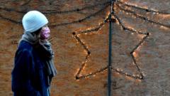 A woman in a face mask passes a Christmas decoration in Berlin, 16 December 2020