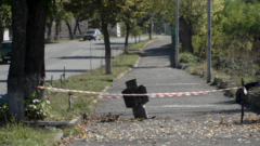 Неразорвавшийся снаряд торчит из дороги в Степанакерте