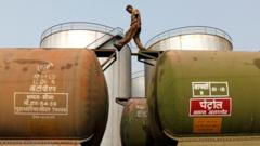 Рабочий идет по вагону-цистерне на нефтяном терминале недалеко от Калькутты