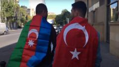 Два парня на дороге. У одного на плечах азербайджанский флаг, у другого - турецкий.