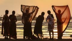 Женщины на пляже Мумбая в экстремальную жару 15 мая 2023 года