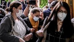 Valérie Bacot (C) arrives flanked by relatives and journalists at the Chalon-sur-Saone Courthouse, central-eastern France, on June 25, 2021