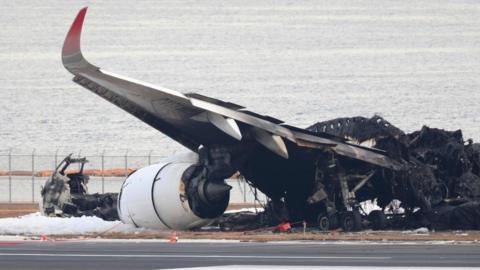 A Japan Airline passenger plane burnt out is remained on the tarmac at Haneda Airport in Tokyo, Japan, 03 January 2024 after colliding with a Japan Coast Guard plane on 02 January 2024.