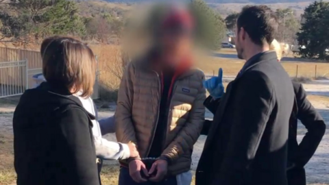 Detectives arrest Matthew James Williams (centre) in Jindabyne last year in vision supplied by police