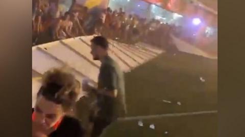 Festival goers shielding themselves from high speed wind