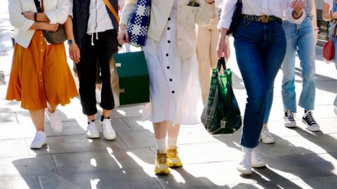 A general view of shoppers with bags walking along a street