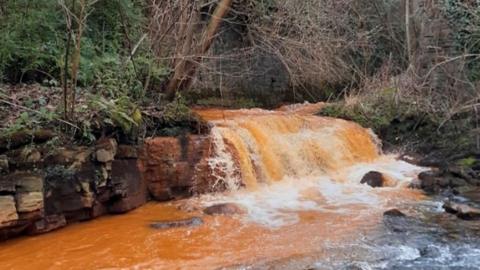 The Afon Lwyd turns orange