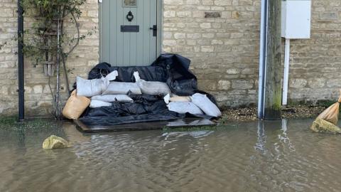 Sandbags stacked in front of a house door