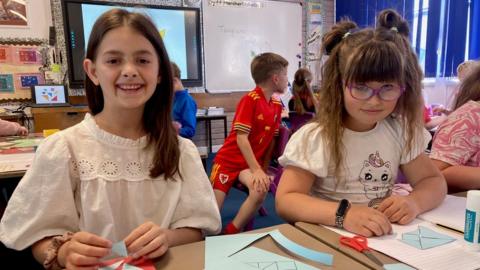 Nataliia and Sofiia in the classroom grinning