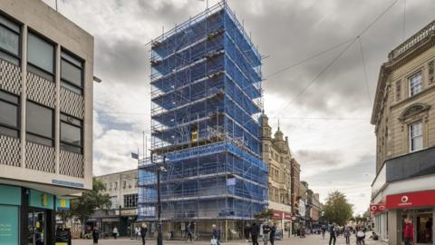 Tower of the former Church of St Michael covered in scaffolding