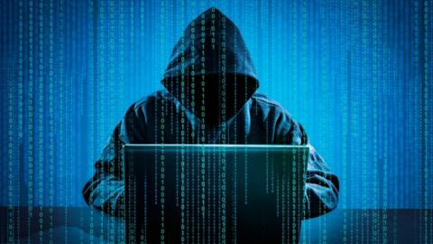 Illustration of computer crime using a hooded character at a laptop