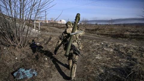 A Ukrainian serviceman walks towards the front line in Irpin last year