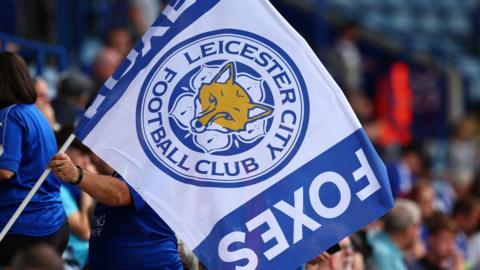 A fan holds a Leicester City flag