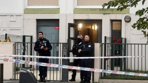 French police stand in front of a building where five bodies were found dead in Meaux, near Paris