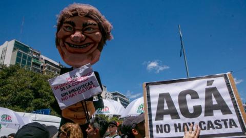 Protesters hold aloft a puppet of Milei during protests in Buenos Aires