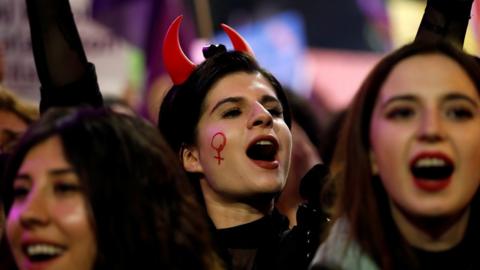 Woman with devil horns on march marking International Women's Day in Istanbul