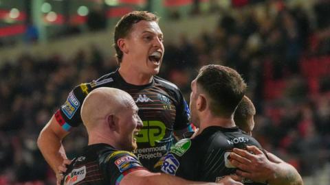 Wigan players celebrate late try at Salford
