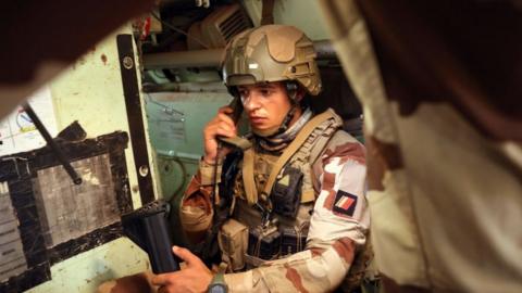 A French soldier of the Barkhane force speaks with a phone in an armoured vehicle while patrolling the streets of Timbuktu, northern Mali, on December 5, 2021.