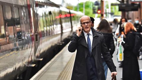 A man makes his way onto a train at Stoke-on-Trent Train Station on 20 May 2021 in Stoke, England