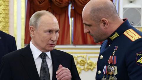 President Vladimir Putin speaking with Lieutenant Colonel Artyom Zhoga during a ceremony to present Gold Star medals to Heroes of Russia at the Grand Kremlin Palace in Moscow on December 8, 2023.