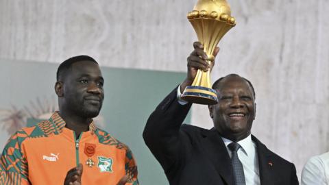 Emerse Fae and Ivorian President Alassane Ouattara with the Africa Cup of Nations trophy