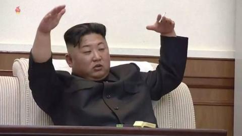 Kim Jong-un gestures with a cigarette in his hand