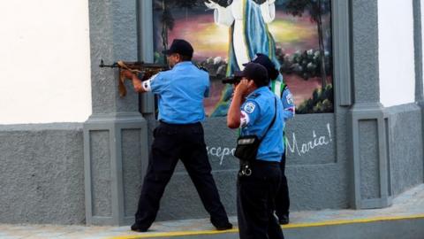 A police officer prepares to fire a weapon during clashes with anti-government protesters i in Masaya, on 13 July, 2018