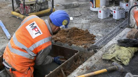 A workman works on the site of the new Wharfeside tram stop in Trafford Park in Manchester