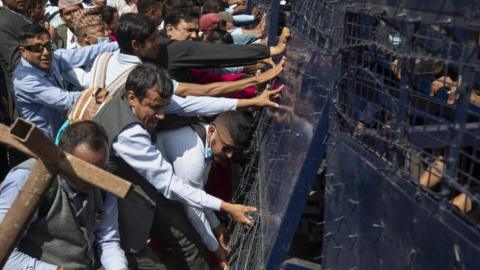 Nepalese school teachers try to break the barricade of the restriction zone in front of the parliament building