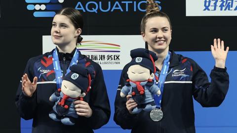 Andrea Spendolini-Sirieix and Lois Toulson wave on the podium