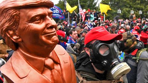 A supporter of US President Donald Trump wears a gas mask and holds a bust of him after he and hundreds of others stormed stormed the Capitol building on 6 January 2021 in Washington, DC, US.