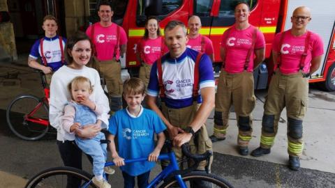Ms Parsons with her husband Matt, their two young children and six firefighters from Avon Fire and Rescue.