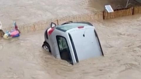 Car half submerged in Bulgaria floodwaters