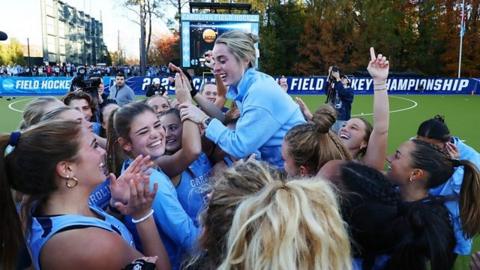 Head coach Erin Matson of the North Carolina Tar Heels is lifted up by her team after defeating the Northwestern Wildcats