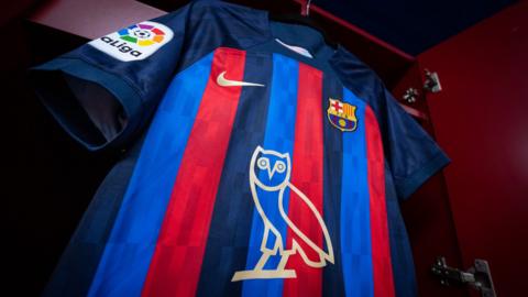 A hanging Barcelona shirt with Drake's logo on the front