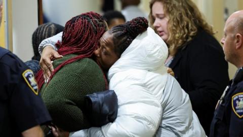 Families of victims hug outside the courtroom