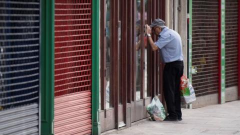 A man looks into a closed coffee shop