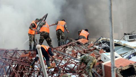 Rescue workers at the site of an airstrike in Damascus, Syria