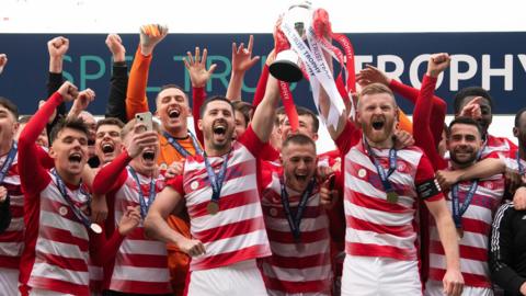 Hamilton Accies players celebrate and lift the SPFL Trust Trophy