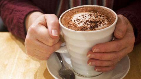 A woman holds a cup of hot chocolate