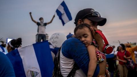 A father holds his son during one of the many demonstrations calling for the resignation of President Ortega in April 2018.